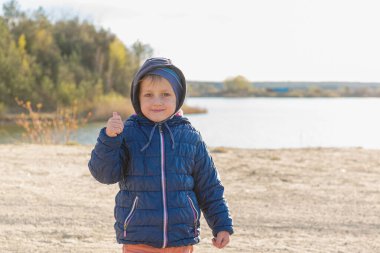 Mavi ceketli yakışıklı bir Avrupalı çocuk doğada duruyor. Sevimli bir bebeğin portresi. Adam..
