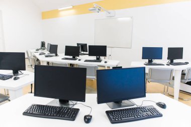 Klavyeli bilgisayar tablolu bir ofis odası ve projektörlü bir fare. 
