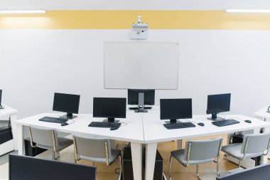 Klavyeli bilgisayar tablolu bir ofis odası ve projektörlü bir fare. 