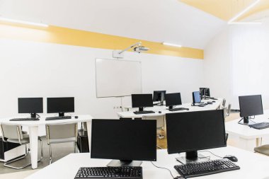Klavyeli bilgisayar tablolu bir ofis odası ve projektörlü bir fare. 