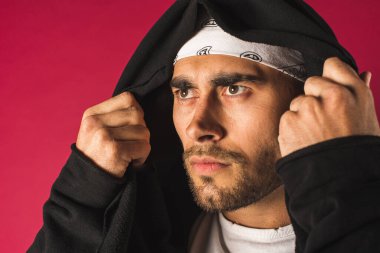 Hoş, komik, çılgın, duygusal, yakışıklı, çekici bir adamın portresi. Kırmızı arka planda izole edilmiş parlak bir tişört içinde çeşitli el hareketlerini gösteriyor.