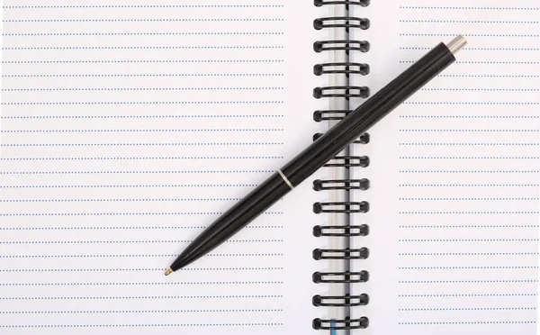 Pluma negra en la parte superior del cuaderno blanco Imagen de archivo