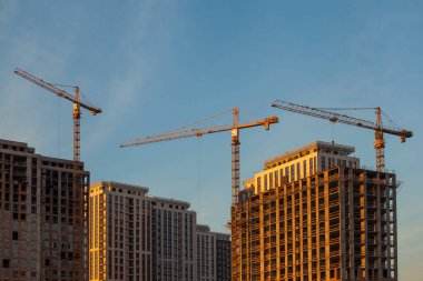 Mavi gökyüzüne karşı vinçleri olan inşaat alanı