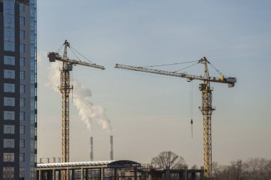 Mavi gökyüzüne karşı vinçleri olan inşaat alanı