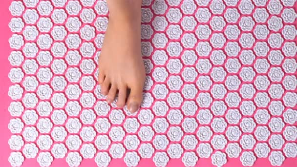 Female feet gently tread on acupuncture massage mat. Top view. — Stock Video