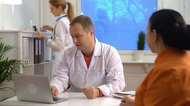 Dokter kalmeert haar oudere patiënt en met haar hand. — Stockvideo