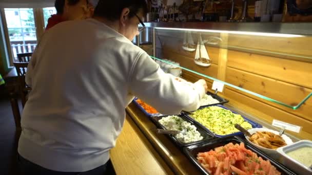 Die Restaurantgäste wählen Speisen vom Buffet aus. Kugelstoßer. — Stockvideo