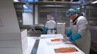 Bir deniz ürünleri işleme fabrikası çalışma takımı. İşçiler balık plastik paketi..