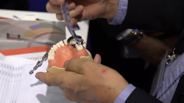 Especialista prueba un nuevo equipo de estomatología para el maniquí dental . — Vídeo de stock