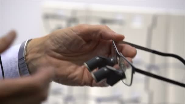 Seller demonstrates new dental loupes lens high resolution. — Stock Video