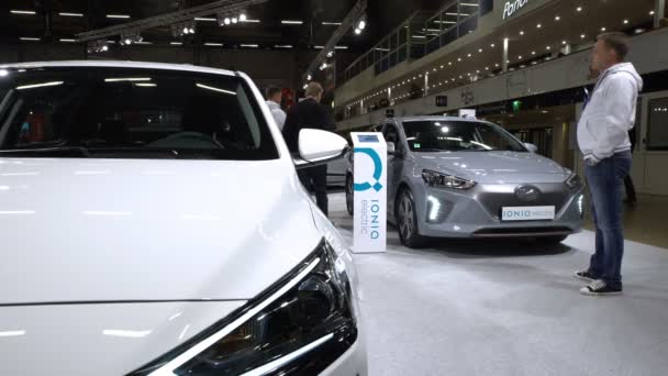 Besucher begutachten Neuwagen Hyundai ioniq electric und Hyundai ioniq hybrid. — Stockvideo