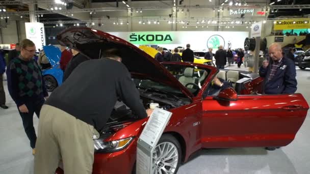 Stand der neuen Modelle Mustang auf der Auto Show. Besucher begutachten Motor eines neuen Fahrzeugs — Stockvideo