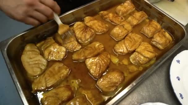Chefe lubrifica os pedaços de molho de peixe na cozinha do restaurante . — Vídeo de Stock