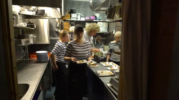 Die Kellnerin bringt das fertige Gericht aus der Küche in den Flur. — Stockvideo
