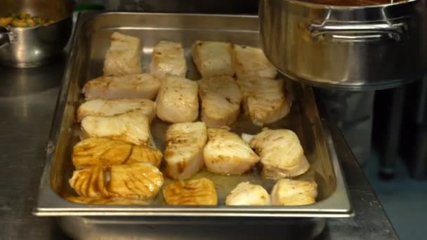Cozinhar pratos de marisco. Chefe lubrifica os pedaços de molho de peixe na cozinha do restaurante . — Vídeo de Stock