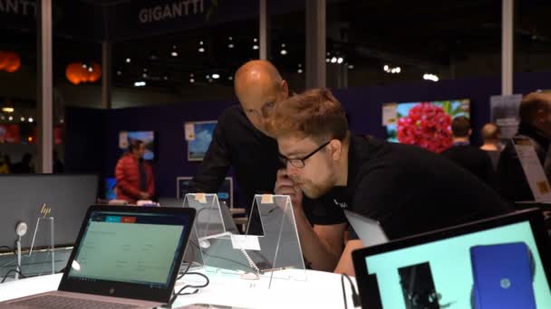 Twee mannen overweegt een laptop met touchscreen in een elektronicawinkel. — Stockvideo