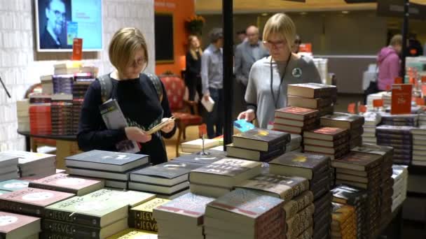 Muchos amantes de la lectura, compradores, editores y libros en la gran feria del libro . — Vídeo de stock