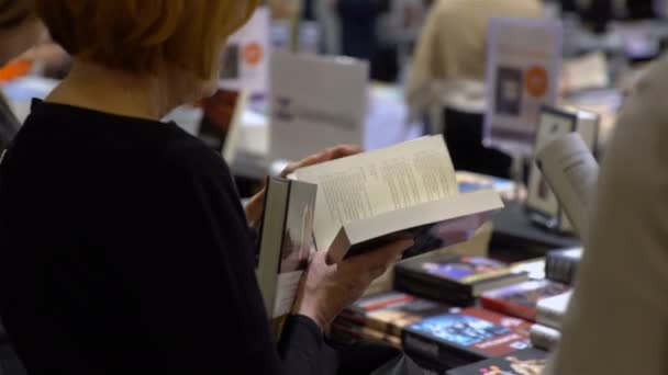 Vele liefhebbers van lezen, kopers, uitgevers en boeken op de grote boekenbeurs. — Stockvideo