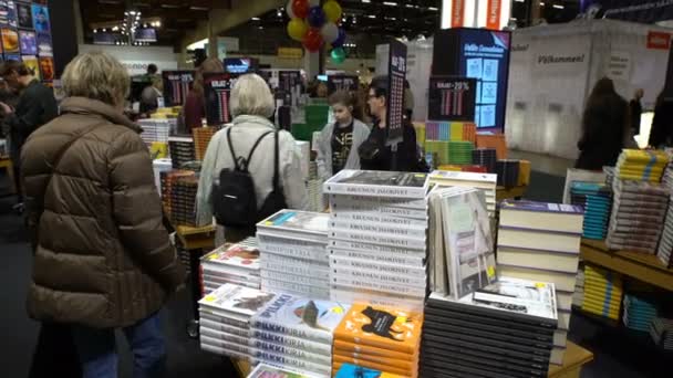 Многие любители чтения, покупатели, издатели и книги на большой книжной ярмарке . — стоковое видео