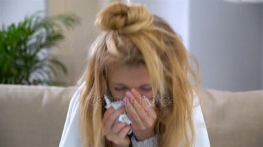 Bir kadınla akıntısı burun kullanır burun spreyi ve hapşırma yüksek sesle.