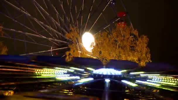 Grande roue dans le parc d'attractions dans les lumières festives en action. Délai imparti . — Video