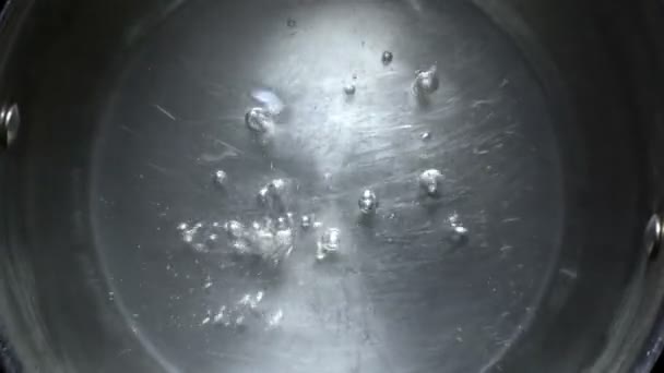 Το νερό βράζει σε μεταλλικό τηγάνι. Μεγεθύνετε. Η περιστροφή της κάμερας. Το Top view. — Αρχείο Βίντεο