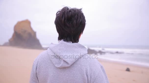 Aantrekkelijke actieve volwassen vrouw staande op een strand van de Oceaan en lachend op camera. — Stockvideo