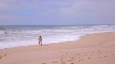 Olgun çekici kadın ve yetişkin kızı ıssız Sahilde yürüyüş.
