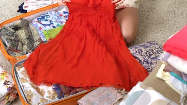 Frau packt Gepäck für eine neue Reise, rotes Kleid, Zeitlupe — Stockvideo