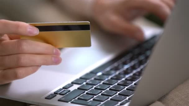 Приваблива молода жінка, що здійснює онлайн-покупки, використовує золоту кредитну картку . — стокове відео