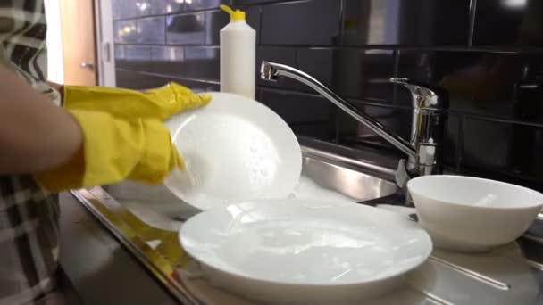 Η νοικοκυρά πλένει τα πιάτα στο νεροχύτη στην κουζίνα. Κουκλίτσα — Αρχείο Βίντεο