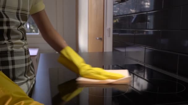 Housewife wipes the surface of the electric stove with a special cleaning cloth. Dolly. Slow motion — Stock Video