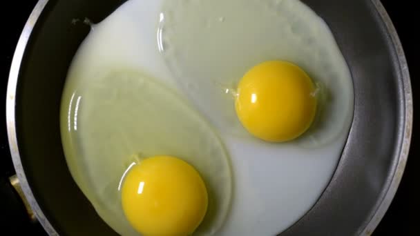Deux œufs frits dans une poêle. Temps écoulé. Zoom. La rotation de la caméra. Vue du dessus .
