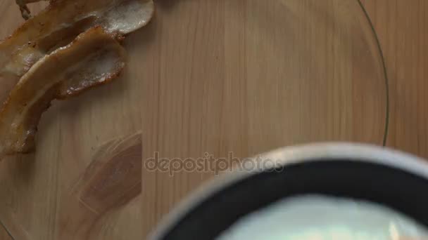 Πρωινό μπέικον και αυγά σε ένα ξύλινο τραπέζι. Το Top view. — Αρχείο Βίντεο