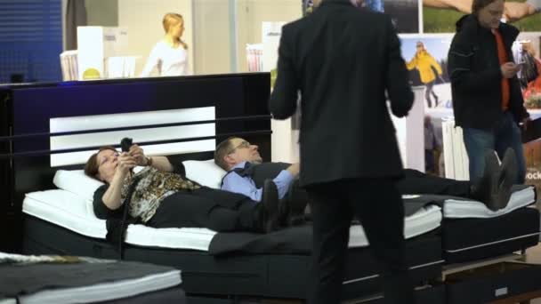 Köpare upplever en ny ortopedisk säng med fjärrkontroll. — Stockvideo