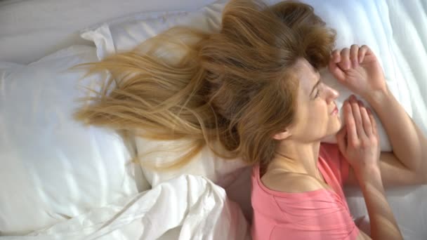 Jovem sonolenta infeliz não quer acordar de manhã e se esconder sob o cobertor . — Vídeo de Stock