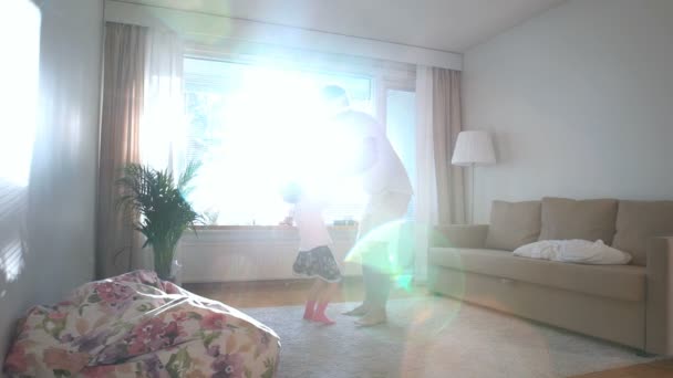 Papa draait en werpt kleine dochter op handen in de zonnige kamer. Slow motion — Stockvideo