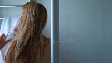 Genç kadın almak bir havlu ince ve saçın duştan sonra silin. Ağır çekim. Dolly kısa.