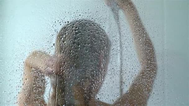Jeune femme mince prenant une douche et se lavant les cheveux. Mouvement lent . — Video