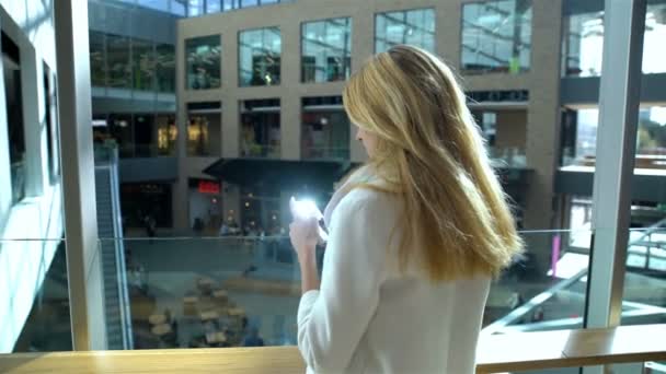 Jeune femme mince utilise un smartphone dans le commerce et le centre de bureau — Video