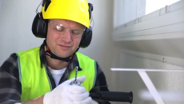 Bauarbeiter mit einem Bohrer, der in die Kamera lächelt. Zeitlupe. — Stockvideo