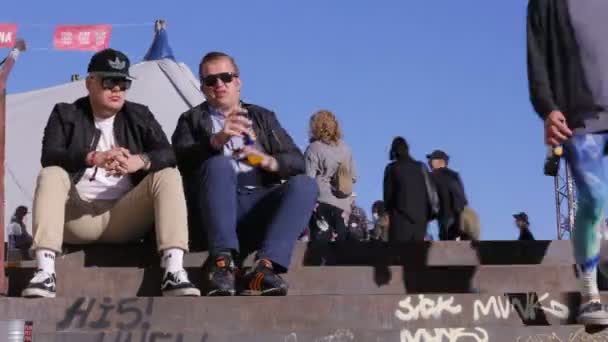 Jóvenes despreocupados sentados en las escaleras y hablando. Tiempo de caducidad . — Vídeos de Stock