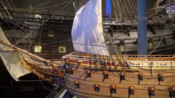 Model van houten vechten schip uit de 17e eeuw tegen de achtergrond van het gereconstrueerde schip Vasa in het hetzelfde museum. Dolly schot. — Stockvideo