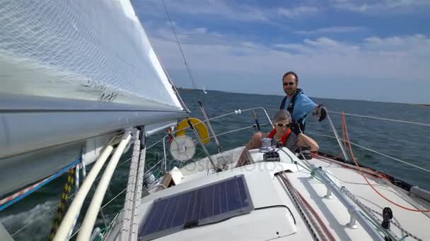 Zeiltocht. Een paar van de directe zeilboot zeilers in de open zee. — Stockvideo