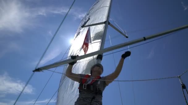 Un marinaio donna cambia lo Spinnaker sulla prua dello yacht . — Video Stock