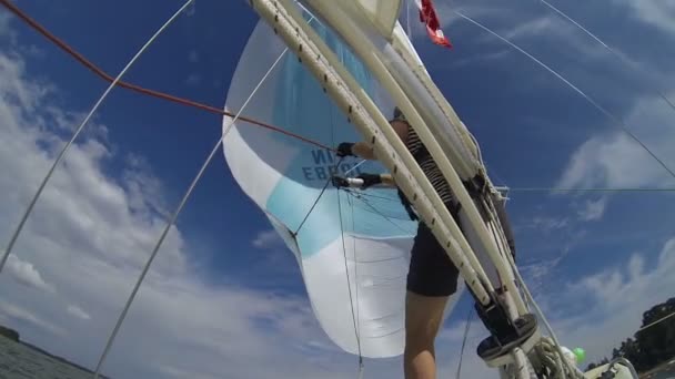 Жінка Матрос змінює Спінакер на носі яхти. — стокове відео