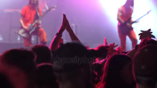 Beaucoup de fans applaudissent et saluent leurs mains lors d'un concert de rock . — Video