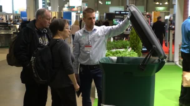 Консультант в магазине демонстрирует новый высокотехнологичный контейнер для сортировки и утилизации мусора . — стоковое видео