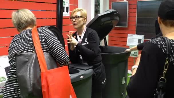 Консультант в магазине демонстрирует новый высокотехнологичный контейнер для сортировки и утилизации мусора . — стоковое видео