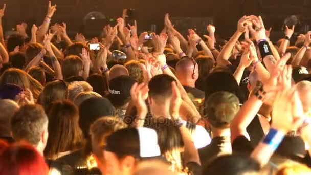 Mange fans klapper og vinker med hænderne ved en rockkoncert. Langsom bevægelse – Stock-video